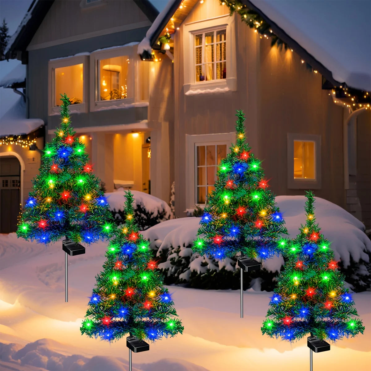 Decorative Christmas trees with colorful lights in front of a house during winter.